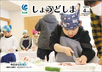 広報誌4月号の表紙で、小学生が包丁を持ち、真剣な表情で地魚の切り身を食べやすい大きさに切っている画像