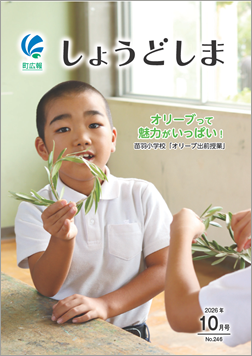 広報10月号の表紙で、オリーブ出前授業でオリーブの枝葉を持つ小学生の画像