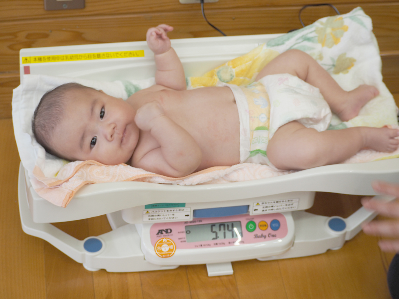 赤ちゃんが体重計に乗っている画像