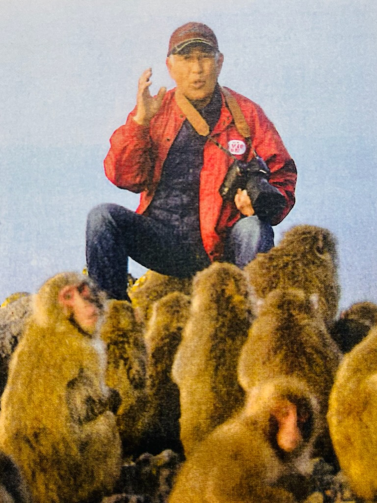 サルとコミュニケーションをとる中塚正春さんの写真