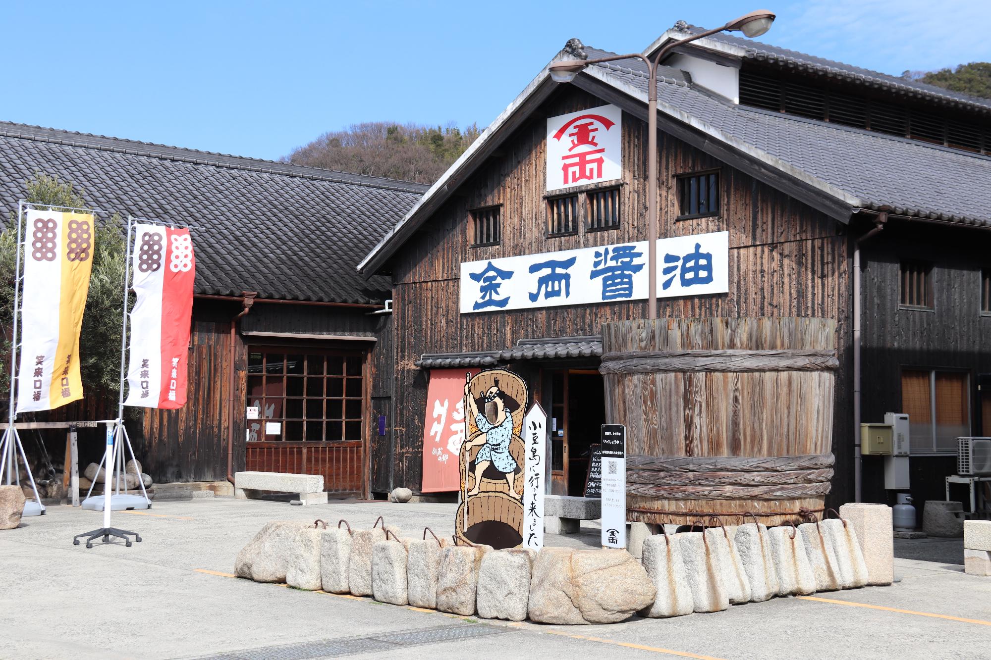 醤油蔵の前に重しとして使われていた石の道具が並べられている