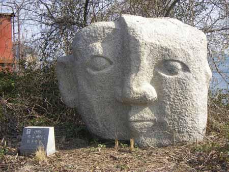 人の顔の形に掘られた大きな石彫の写真