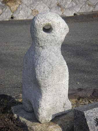 ペンギンのような形の石の上真ん中が貫通している石彫の写真