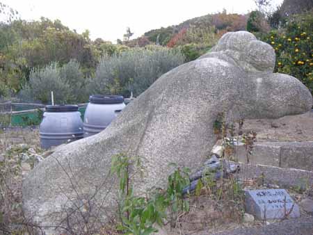 山のような、人がうつ伏せになって寝ている様な形をしていて、頂上に丸い形が並ぶ石彫の写真