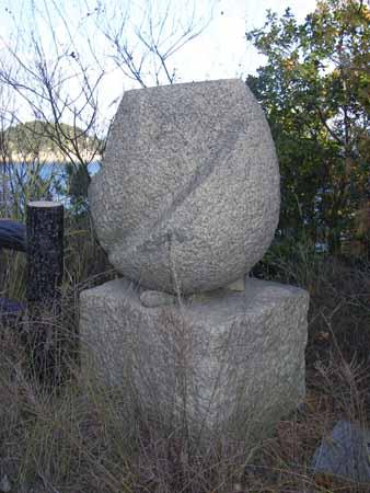 四角形の土台の上に、卵型の石がのって、斜めをそぎ取られたような形の石彫の写真