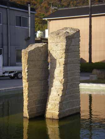 縦に長い形で横じまの溝が等間隔に10本ほど入っている2つの石彫の写真