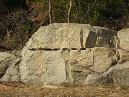 大きな石の中央に切れ目がある石彫の写真