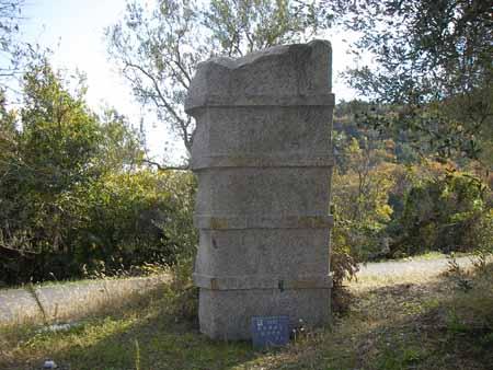 塔のような石に4つの太い線が規則的に入っている石彫の写真
