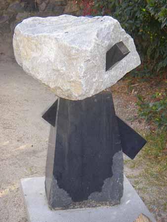 黒いペンギンのような体の形の石に、頭のような白い石が突き刺ささっている石彫の写真