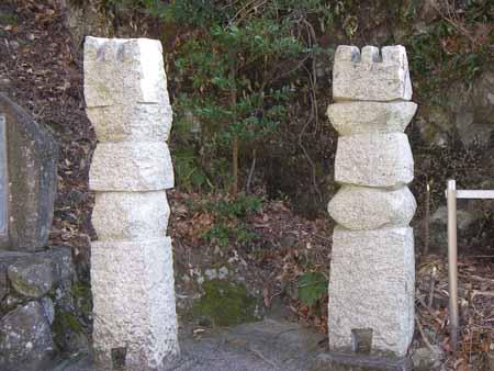 四角い石の上に丸い石、その上に四角の2つの石、一番上に山の字のような石と5つの石が積み重なっている石彫が2本ある写真