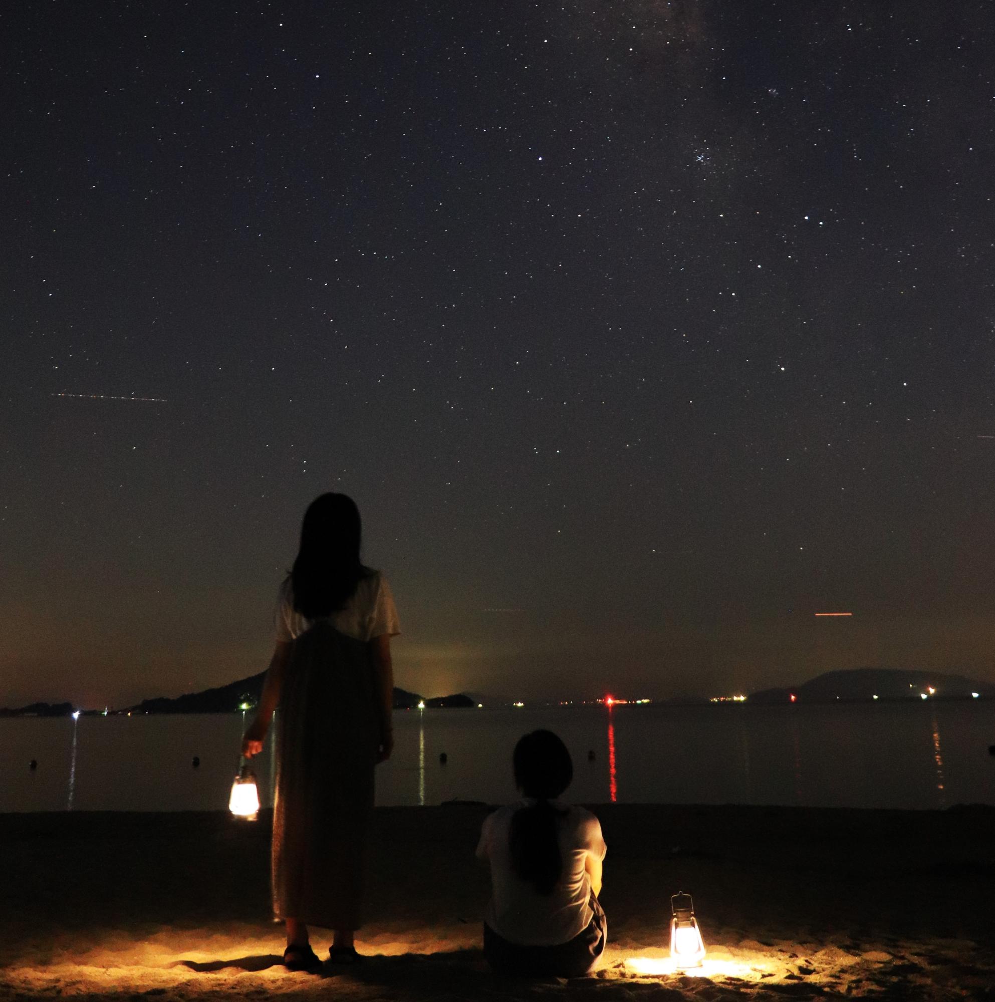 オリーブビーチで夜空を見る女性の写真
