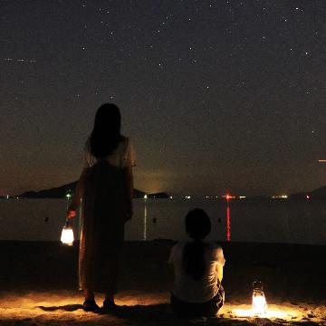 オリーブビーチで夜空を見る女性の写真