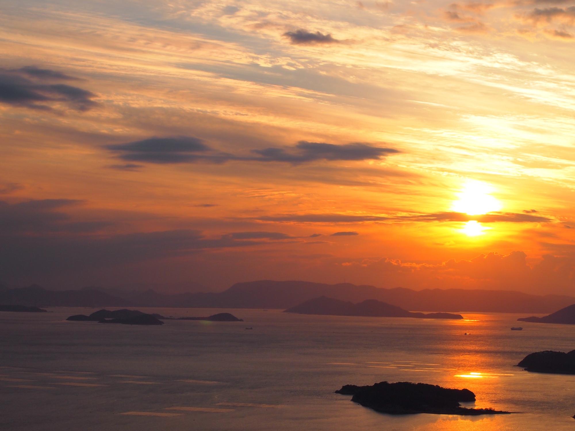 西の滝から眺めた夕日と瀬戸内海の写真