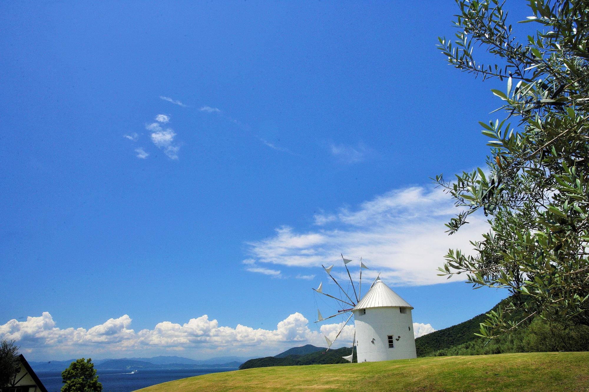 公園内の小高い丘の上のギリシャ風車の写真