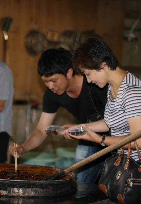 小豆島食品で佃煮を試食する男女の写真